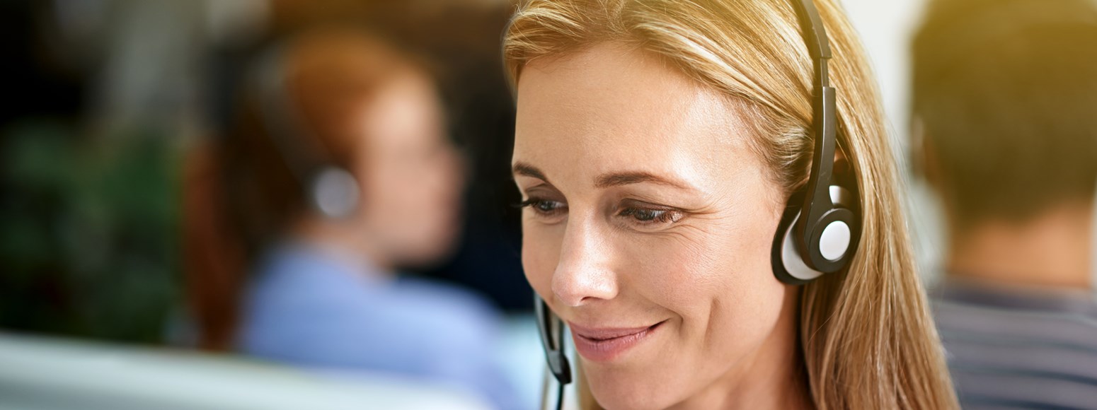 lächelnde Call-Center-Mitarbeiterin mit Headset (Kundenservice)